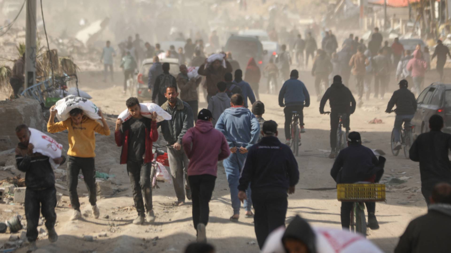 فلسطينيون يحملون مساعدات إنسانية في مدينة غزة