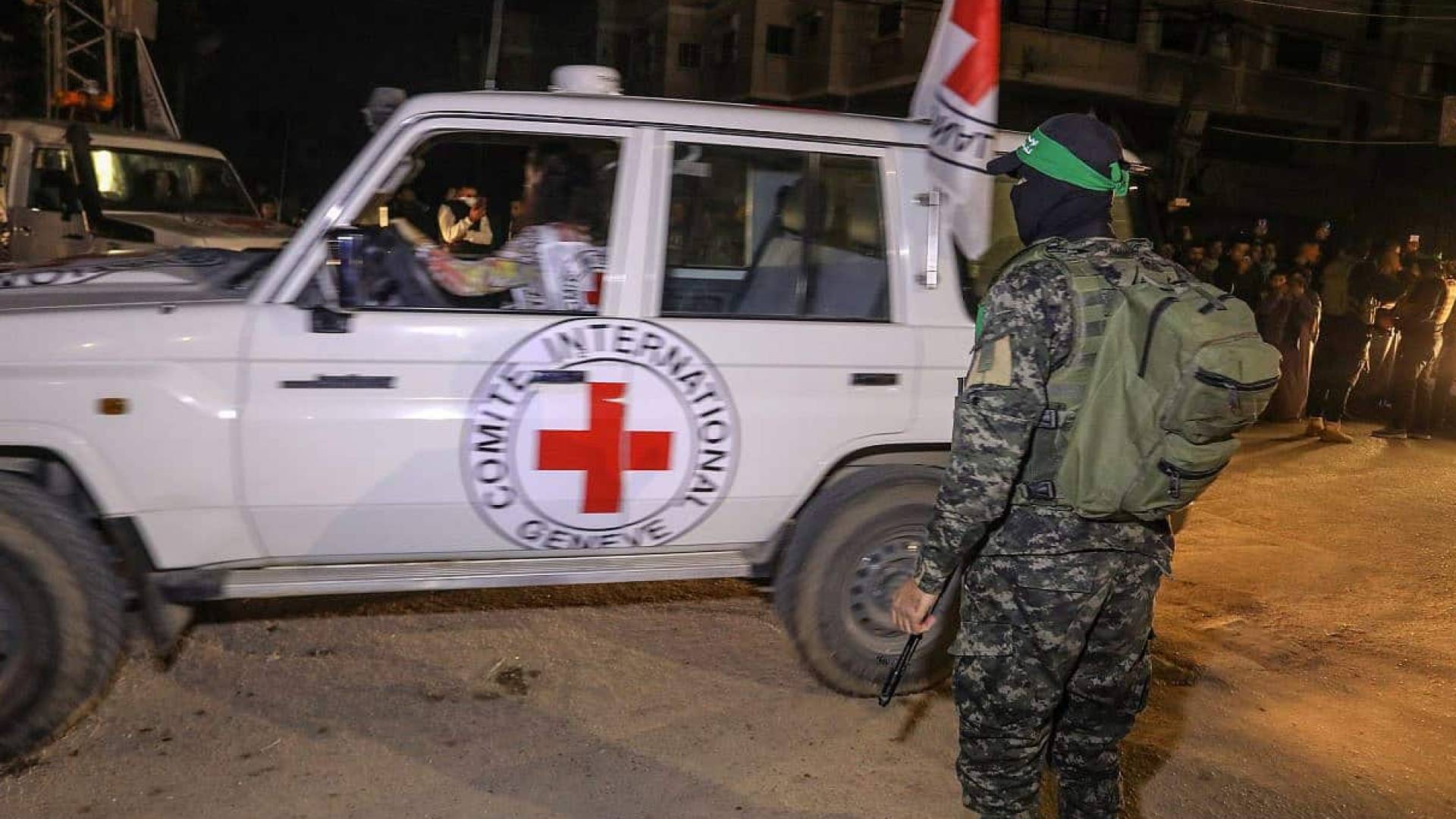 مقاتل من كتائب القسام رفقة سيارة الصليب الأحمر لنقل المحتجزين