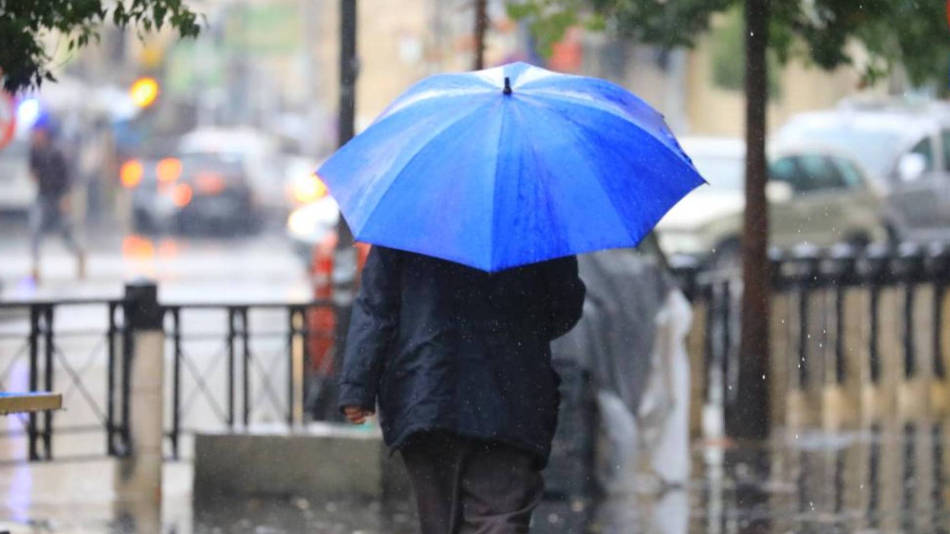 رجل يسير تحت المطر